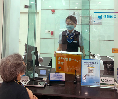 建行成都金河支行，柜面員工使用“關愛服務卡”服務老年客戶